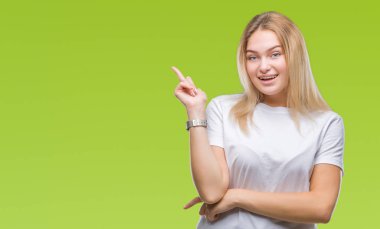 Kameraya bakarak yan el ve parmak ile işaret izole arka yüzünde kocaman bir gülümseme ile genç beyaz kadın.