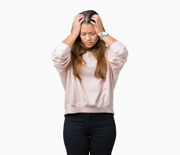 必死と強調した頭痛に苦しんで孤立の背景にピンクのトレーナーを着ている若い美しいブルネットの女性の痛みと片頭痛 頭に手 — ストック写真