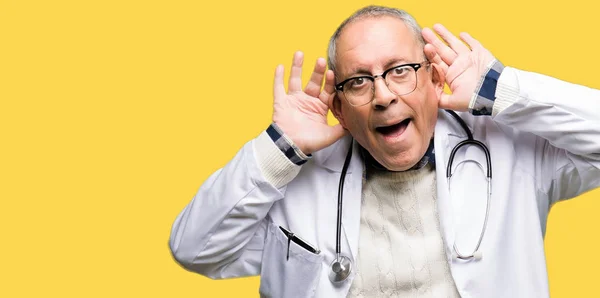 Όμορφος Ανώτερος Γιατρός Άνθρωπος Φορώντας Ιατρική Παλτό Προσπαθώντας Ακούσω Δύο — Φωτογραφία Αρχείου