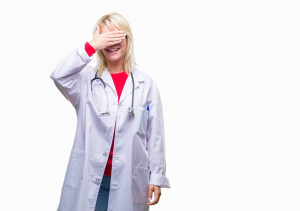 美しい金髪女医女性は微笑し 笑う顔驚きの目を覆っている手で孤立した背景に医療制服を着てします 視覚障害者の概念 — ストック写真