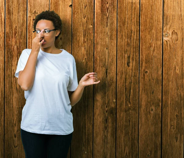 Hermosa Mujer Afroamericana Joven Con Gafas Sobre Fondo Aislado Oliendo — Foto de Stock