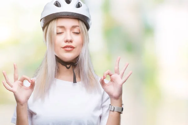 年轻的金发女子穿着自行车安全头盔在孤立的背景下放松和微笑闭上眼睛做冥想手势与手指 瑜伽理念 — 图库照片