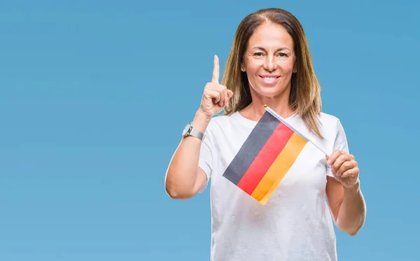 中世纪西班牙裔妇女持有德国国旗在孤立的背景下惊讶的想法或问题指着一个快乐的脸 — 图库照片