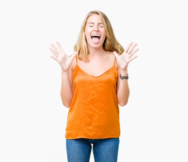 狂牛病と悲鳴上げられたとクローズの目が興奮して腕の成功のために狂気を祝う孤立の背景にオレンジ色のシャツを着て美しい若い女性 勝者の概念 — ストック写真