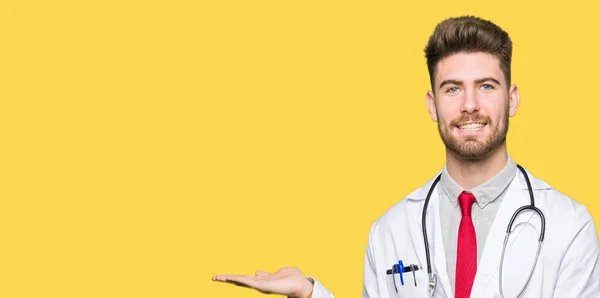 Jonge Knappe Dokter Man Met Medische Vacht Lacht Vrolijk Presenteren — Stockfoto