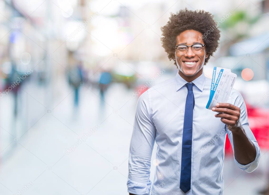 Afro american man holding boarding pass over isolated background with a happy face standing and smiling with a confident smile showing teeth
