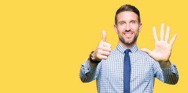 Yakışıklı iş adamı giyen kravat gösterme ve parmak altıncı ile gülümseyen ise kendinden emin ve mutlu yukarı dönük.