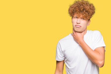 Casual beyaz t-shirt giyen afro saçlı yakışıklı delikanlı ağrılı boyun, boğaz gribi, kesek ve enfeksiyon için dokunaklı