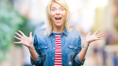 Üzerinde kot ceket giyen genç güzel sarışın kadın deli kutluyor arka plan izole ve silah ile başarı için yükseltilmiş ve açık gözleri heyecanlı çığlık hayrete düşürdü. Kazanan kavramı