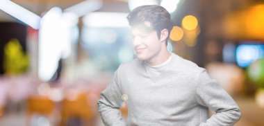 Üzerinde sweatshirt giyen genç yakışıklı sportif adam izole mide üzerinde el ile arka plan çünkü hazımsızlık, ağrılı hastalık hasta hissediyor. Ağrısı kavramı.