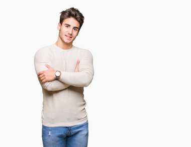 İzole arka plan mutlu yüz çapraz silah kameraya bakarak ile gülümseyen genç yakışıklı adam. Olumlu bir kişi.