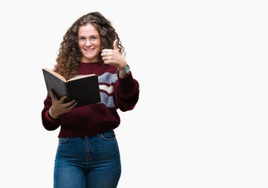 Genç esmer kız ok işareti, başparmak ile parmak, mükemmel işareti yapıyor kocaman bir gülümseme ile izole arka plan üzerinde mutlu gözlük takan bir kitap okuma