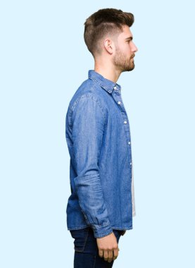 Tarafına, seyir rahat denim ceket giyen genç yakışıklı sarışın adam sakin ol kendine güvenen gülümseme ile doğal yüz pozuyla profili.