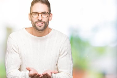 Genç yakışıklı adam gözlük izole üzerine gülen alma veya jest vererek birlikte el avuç içi ile arka plan. Ayrı tutma ve koruma