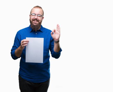 Gözlük takan ve boş kağıt tutan genç hipster adam arka plan parmak, mükemmel sembolü ile ok işareti yapıyor izole