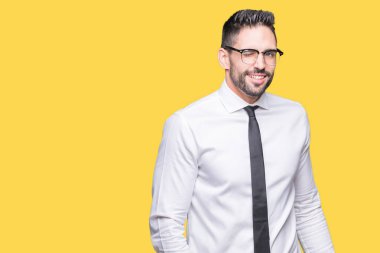 Seksi bir ifadeyle, neşeli ve mutlu yüzünü kameraya bakarak göz kırpıyor izole arka plan üzerinde gözlük takan genç yakışıklı iş adamı.