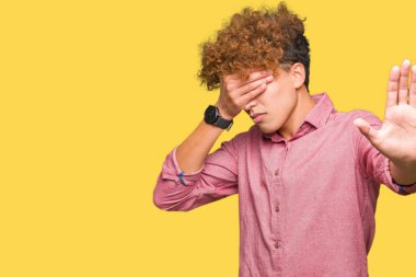 Genç yakışıklı iş adam elleriyle gözlerini kapsayan afro saçlı ve stop jest ile acı ve korku ifadesi. Utandım ve negatif kavramı.