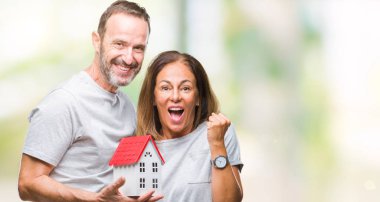 Orta yaş İspanyol rahat çift yeni ev satın alma gurur çığlık ve zafer ve başarı çok heyecanlı, duygu tezahürat kutluyor arka plan izole