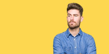 Genç yakışıklı sarışın adam görünümlü yan ve dik dik bakma uzağa düşünce gülümseyen rahat kot gömlek giymiş.