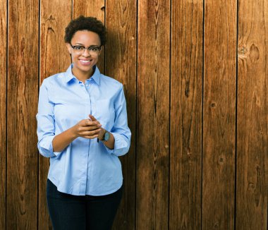 Genç güzel Afro-Amerikan iş kadını izole arka plan el ele tutusun ve parmaklar üzerinde rahat ve neşeli gülümseyen geçti. Başarı ve iyimser