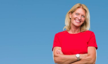 Orta yaş sarışın kadın izole arka plan mutlu yüz çapraz silah kameraya bakarak ile gülümseyen yüzünden. Olumlu bir kişi.