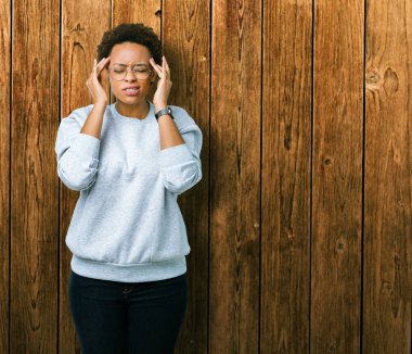 Genç güzel Afrikalı-Amerikalı kadın üzerinde gözlük takan izole arka plan baş baş ağrısı için el ile çünkü stres. Migren muzdarip.