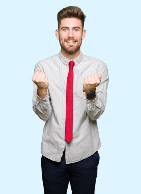 Genç yakışıklı iş adamı kutluyor şaşırttı ve başarı için kaldırdı kollarını açarak hayret ve gözleri açık. Kazanan kavramı.