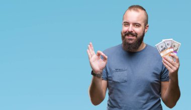 Parmak, mükemmel sembolü ile ok işareti yapıyor izole arka plan üzerinde para tutan genç hipster adam