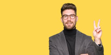 Mutlu yüz zafer işareti yaparken kameraya göz kırpıyor ile gülümseyen gözlüklü genç yakışıklı iş adamı. İki numaralı.