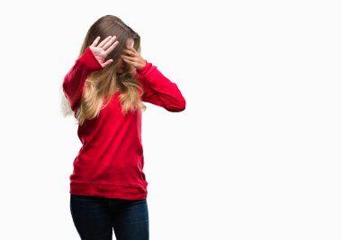 Üzerinde kırmızı kazak giyen genç güzel sarışın kadın izole elleriyle gözlerini kapsayan arka plan ve stop jest ile acı ve korku ifadesi. Utandım ve negatif kavramı.