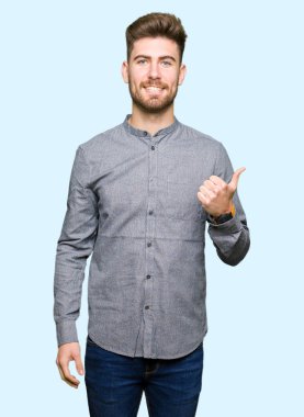 Genç yakışıklı iş casual adam mutlu yaşasın el hareketini yapıyor. Kameraya bakarak başarı gösteren ile ifade onaylama.