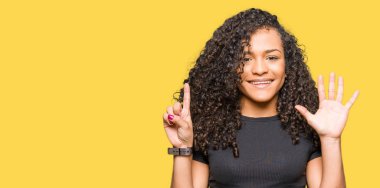 Gösterilen ve parmakları ile işaret kıvırcık saçlı Genç güzel kadın kendinden emin ve mutlu gülümseyerek süre 6 numara.