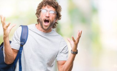 Sırt çantası ve gözlük üzerinde giyen yakışıklı İspanyol öğrenci adam deli kutluyor arka plan izole ve başarı için kaldırdı kollarını açarak hayrete ve heyecanlı çığlık gözleri açık. Kazanan kavramı