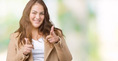 Artı boyutu genç kadın güzel üzerinde kış palto giyiyor için fotoğraf makinesi ile mutlu ve komik yüz parmakları işaret arka plan izole. İyi enerji ve vibes.