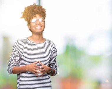 Güzel genç Afro-Amerikan kadın üzerinde gözlük takan birlikte arka plan eller izole ve rahat ve neşeli gülümseyen parmak çarpı işareti. Başarı ve iyimser