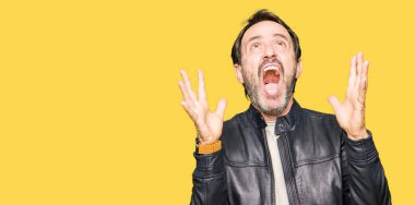 Siyah deri giyen orta yaş yakışıklı adam ceket çılgın ve kızgın bağırarak ve agresif ifade ve silah kaldırdı bağırıyordu. Hayal kırıklığı kavramı.