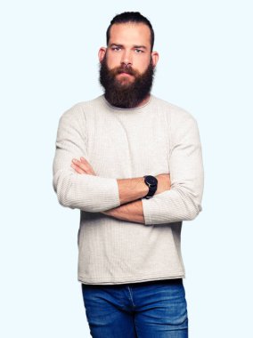 Genç sarışın adam rahat kazak şüpheci ve sinir, onaylamayan ifade yüz çapraz kollu giyiyor. Negatif kişi.