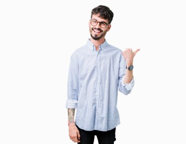 Seyir ve başparmak yanında yukarıyı mutlu yüz ile gülümseyen izole arka plan üzerinde gözlük takan genç yakışıklı adam.