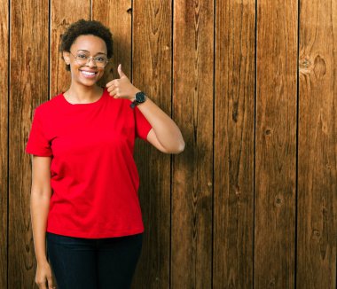 Güzel genç Afro-Amerikan kadın hareketi el ile mutlu yaşasın yapıyor izole arka plan üzerinde gözlük takıyorum. Başarı gösteren kameraya bakarak ifade onaylama.