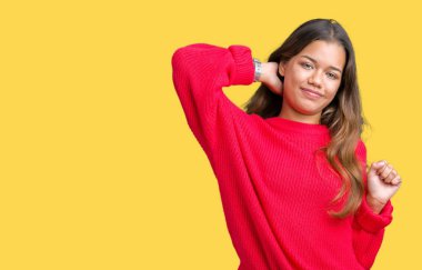 Arka plan geri, yorgun ve rahat, Uykulu ve erken sabah esneme germe üzerinde kırmızı kış kazak giyen genç güzel esmer kadın izole