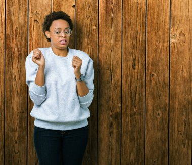 Genç güzel Afrikalı-Amerikalı kadın izole arka plan üzerinde gözlük tiksinti ifadesi, memnun ve korkulu tiksinti yüz yapıyorsun çünkü nefret tepki. Elleriyle kaldırdı. Sinir bozucu kavramı.