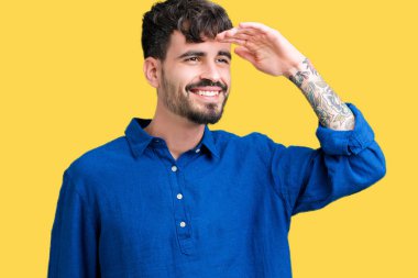 Yakışıklı delikanlı izole arka plan çok mutlu ve gülümseyen uzakta el ile üzerine kafa seyir üzerinde. Arama kavramı.