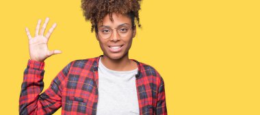 Güzel genç Afro-Amerikan kadın gözlük gösterilen ve parmakları ile işaret izole arka plan üzerinde kendinden emin ve mutlu gülümseyerek süre 5 numara.