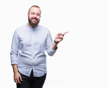 Kameraya bakarak yan el ve parmak ile işaret eden genç beyaz hipster adam yüzünde kocaman bir gülümseme ile izole arka plan üzerinde.
