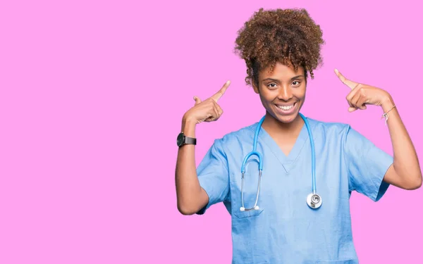 Joven Mujer Médica Afroamericana Sobre Fondo Aislado Sonriendo Señalando Cabeza — Foto de Stock