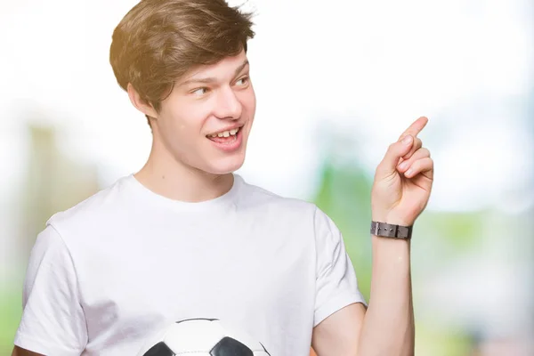 Junger Mann Hält Fußballball Über Isoliertem Hintergrund Und Zeigt Glücklich — Stockfoto