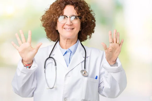 中间的高级医生妇女在孤立的背景显示和指着手指数字十 而微笑着自信和快乐 — 图库照片