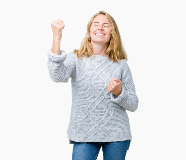 笑顔と成功のために叫んで 上冬のセーターを着ている美しい若い女性は非常に幸せと興奮の腕を上げ 勝者のジェスチャを行う背景を分離しました お祝いのコンセプト — ストック写真