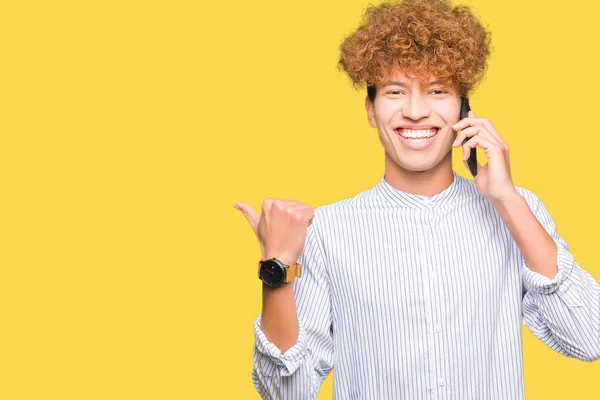 Mladý Pohledný Muž Mluvit Telefonu Směřující Ukazovat Palcem Stranu Úsměvem — Stock fotografie
