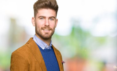 Genç yakışıklı iş adamı uzak tarafına yüzünde, doğal ifade gülümseme ile arıyorum. Kendine güvenen gülüyor.